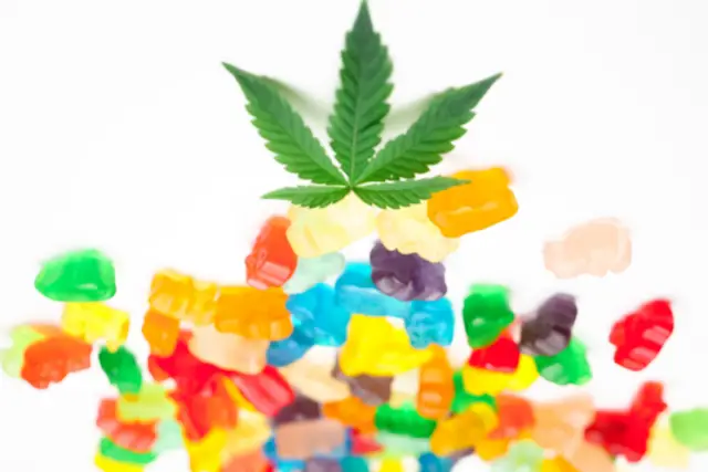 cannabis leaf on top of cbd gummy bears