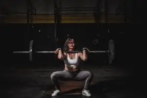 a woman lifting a heaveweight barbell for strength training